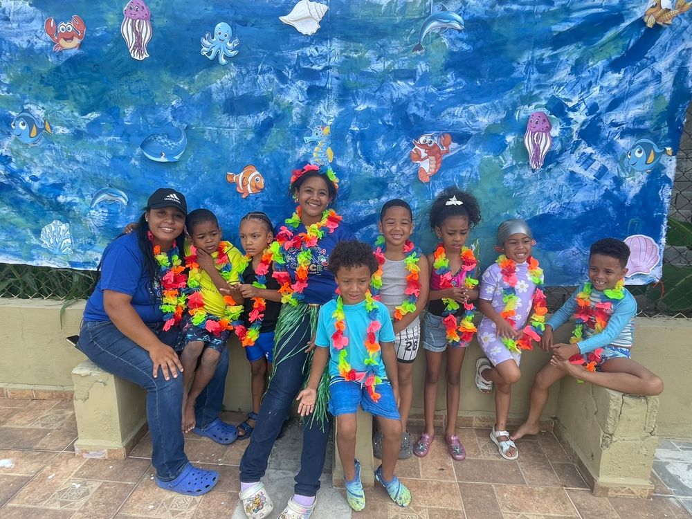 Children celebrating together at the therapeutic camp, wearing flower leis