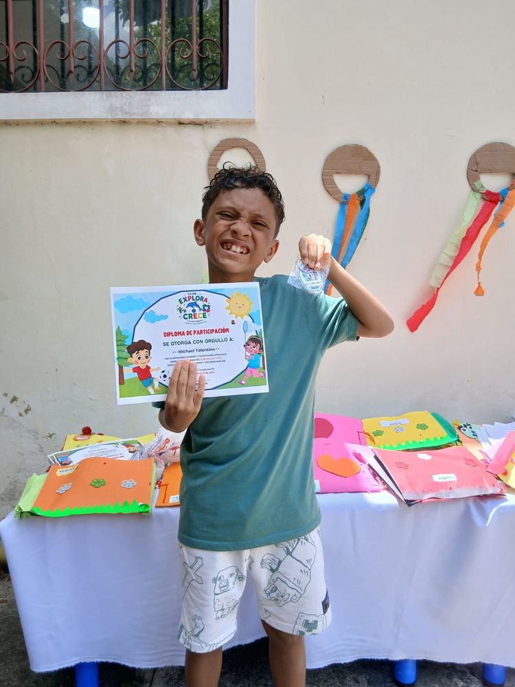 A child proudly holding his certificate of participation